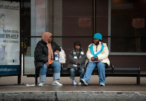 Family sitting at Bus Shelter